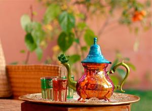 Had Abdallah RhiatRiad Al Mendili Private Resort & Spa的托盘上一个彩色茶壶和两个杯子