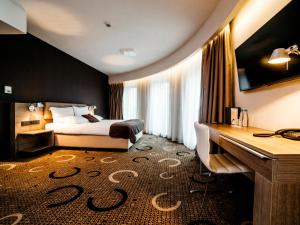 克拉科夫克拉科夫普鲁斯Q酒店的配有一张床和一张书桌的酒店客房