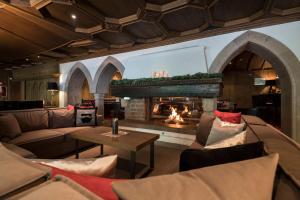 塞尔瓦迪加尔代纳山谷Hotel Aaritz的客厅设有壁炉、沙发和桌子