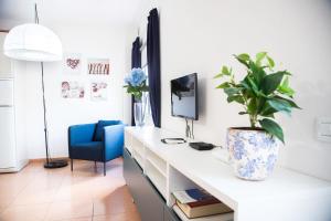 大塔拉哈尔Apartamento con ascensor Gran Tarajal Playa的白色的桌子,上面有盆栽和蓝色的椅子