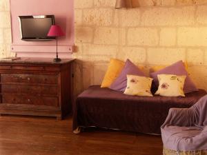 昂古莱姆帕莱斯酒店的一间卧室配有带枕头的床和电视。