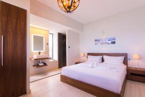 格兰贝伊Azure Beach Boutique Hotel的卧室配有一张白色大床和电视。