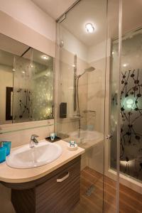 普里什蒂纳纳尔特尔酒店的一间带水槽和淋浴的浴室