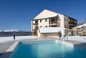丰罗穆千阳欧达利斯公寓式酒店 的雪中带游泳池的房子