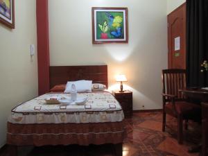 伊基托斯Alojamiento El Cardenal的卧室配有一张床和一张桌子