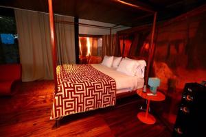 Los Duarte卡米诺太阳住宿加早餐旅馆的一间卧室设有一张大床和一张红色的桌子。