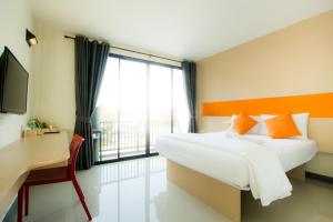 素叻莱芬特酒店的一间卧室配有一张床、一张书桌和一个窗户。