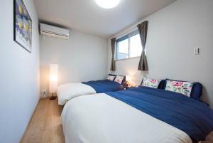 大阪汀科尔贝尔公寓的一间卧室设有两张床和窗户。