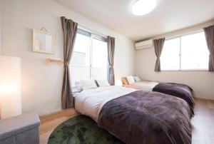 大阪汀科尔贝尔公寓的一间卧室设有两张床和窗户。
