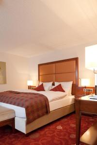 韦默尔斯基兴祖登德雷林登酒店的酒店客房设有一张大床和一张书桌。