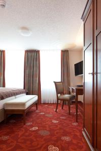 韦默尔斯基兴祖登德雷林登酒店的酒店客房配有一张床、一把椅子和一张书桌