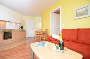 奥斯赛拜-塞林Villa Seerose - Appartement 13的客厅配有红色的沙发和桌子