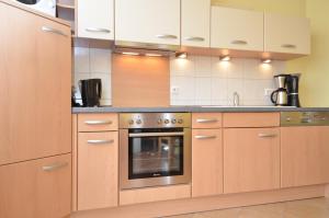 奥斯赛拜-塞林Villa Seerose - Appartement 13的厨房配有木制橱柜和烤箱。