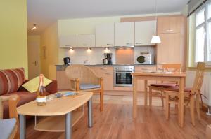 奥斯赛拜-塞林Villa Seerose - Appartement 14的厨房以及带沙发和桌子的客厅。