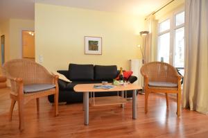 奥斯赛拜-塞林Villa Seerose - Appartement 17的客厅配有沙发、两把椅子和一张桌子