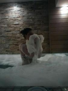 奥格尼亚诺沃Family Hotel Delta的坐在泡沫浴缸里的人