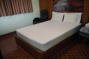 乌隆他尼555 Resort的一张大床,位于带椅子的房间里