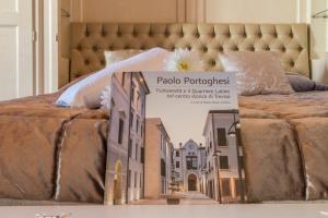 特雷维索圣莱昂纳多拉蒂娜套房公寓的一张床上的书,上面有城市的照片