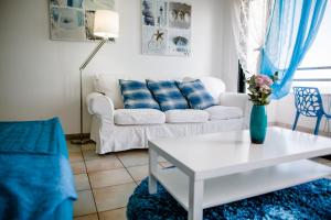 拉纳卡克拉萨斯海滩公寓的客厅配有白色的沙发和桌子