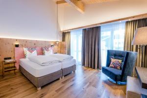 圣安东阿尔贝格"Quality Hosts Arlberg" Hotel zur Pfeffermühle的酒店客房,配有两张床和椅子