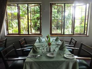 白河Karula Hotel的一间带桌椅和窗户的用餐室