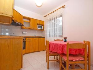 班约勒Apartments Dvorine 1210的厨房配有一张带红色桌布的桌子