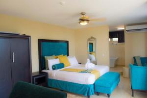 TeshiBest Western Plus Accra Beach Hotel的一间卧室配有一张床和两张蓝色椅子