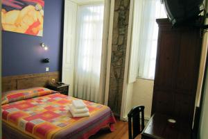 波尔图杜阿斯纳克斯旅馆的一间卧室配有带毛巾的床