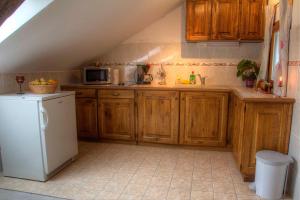 RatkovicaApartman Maryla的厨房配有木制橱柜和白色冰箱。