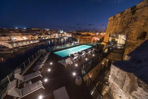 森格莱阿Cugo Gran Macina Malta的游泳池配有躺椅和夜间照明