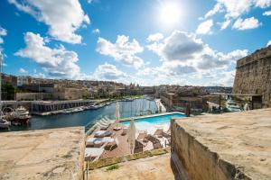 森格莱阿Cugo Gran Macina Malta的享有河流、游泳池和建筑的景色