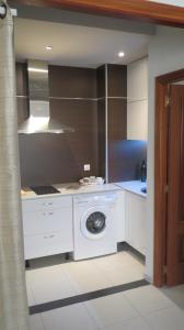 罗萨里奥港海滩附近2V豪华公寓 的客房内的厨房配有洗衣机