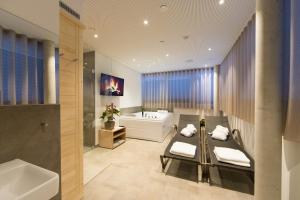 施泰尔Vitus Steyr Hotel & SPA Suites的带浴缸、水槽和浴缸的浴室