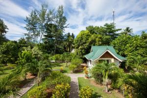 拉迪格岛Chalets d'Anse Reunion的花园中带绿色屋顶的小房子