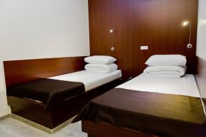 基希讷乌Bed & Breakfast Olsi的小型客房的两张床,设有木墙
