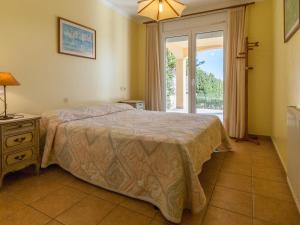 莱斯卡拉Spacious Holiday Home in L Escala with Private Pool的一间卧室设有一张床和一个大窗户