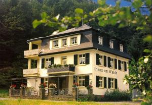 布罗登巴赫Pension "Haus am Walde" Brodenbach, Mosel的带有读写像更新的标志的大房子