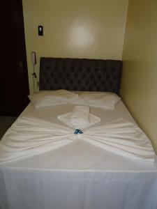 贝伦Hotel Transbrasil的白色的床和白色衬衫