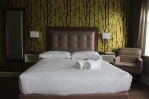 戈尔韦圣茱德斯食宿酒店的一间卧室配有一张床,上面有两条毛巾