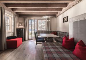 MadonnaHotel & Chalets Edelweiss的客厅配有桌子和红色沙发