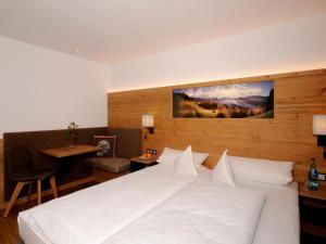 布兰德贝格坦勒旅馆的卧室配有一张白色的大床和一张桌子