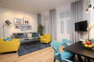 塔林老城套房塔林城市公寓式酒店的客厅配有黄色和蓝色的椅子和桌子