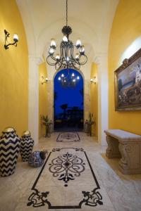 卡波圣卢卡斯El Encanto All Inclusive Resort的一间带吊灯的客厅和一间带桌子的房间