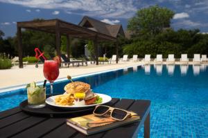 科洛尼亚-德尔萨克拉门托科洛尼亚地道酒店的一张桌子,旁边是一份三明治和饮料