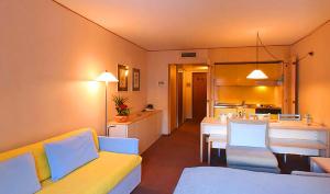普雷圣迪迪埃住宿尤尼沃索酒店的一间带黄色沙发的客厅和一间厨房