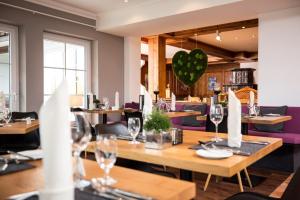 上施陶芬Haubers Naturresort Gutshof的餐厅设有木桌和紫色椅子