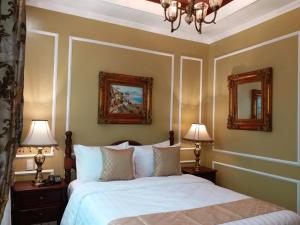 大雅台Lee Boutique Hotel Tagaytay的一间卧室配有一张带两盏灯和两面镜子的床。