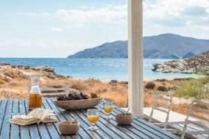 基斯诺斯Eneos Kythnos Beach Villas-Elegant and Comfort Villas的一张带一碗水果的木桌,享有海景