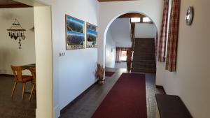 ElmenPension Elmerhof的走廊上设有拱门和红色地毯
