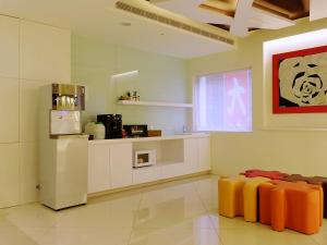 台北璞涟商务旅馆台北车站馆的客房设有带冰箱和桌子的厨房